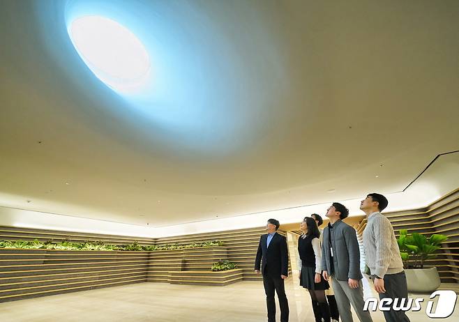 LG 직원들이 LG트윈타워 지하 1층에 새로 조성된 ‘틴들(Tyndall)’에서 햇빛이 들어오는 천장을 바라보고 있다. (LG 제공)