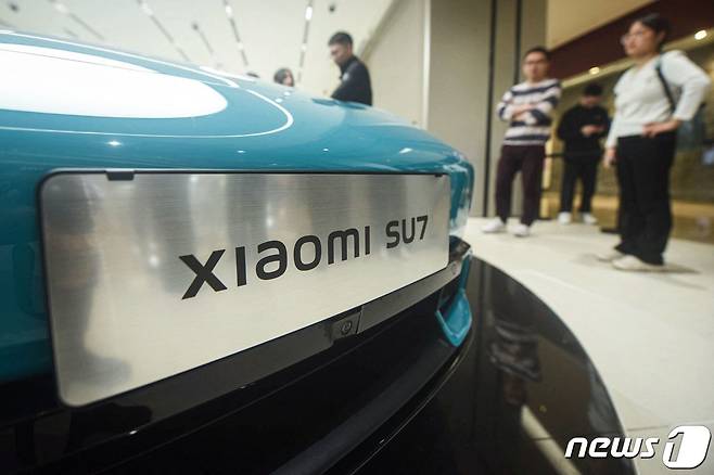 중국 스마트폰 제조업체 샤오미의 첫 전기차인 샤오미 SU7 모델이 동부 저장성 항저우의 한 매장에 전시되어 있다. 2024.3.25 ⓒ AFP=뉴스1