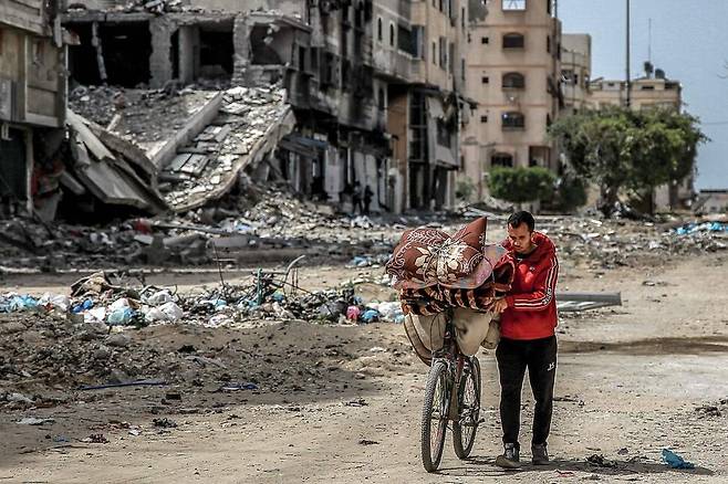 27일 가자지구 가자시티에서 한 주민이 자전거를 끌고 있다. 가자시티/AFP 연합뉴스