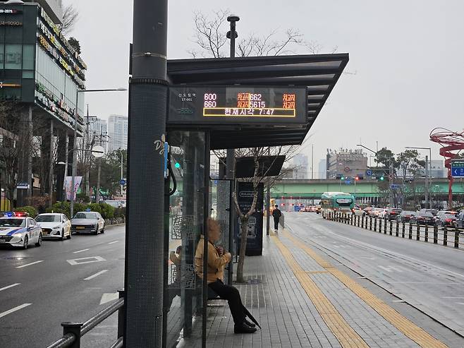 28일 오전 서울 신도림역 앞 버스 정류장에서 버스를 기다리고 있는 한 시민. 그는 전광판에 버스들의 위치가 ‘차고지’라고 쓰여져 있는 것을 보고 이상하다고만 생각했다. 서울시버스노동조합은 이날 오전 4시 첫차부터 운행을 전면 중단했다. [이용경 기자]