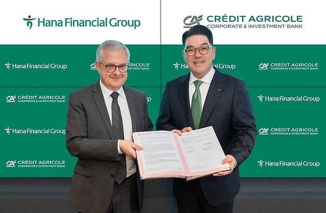 Hana Financial Group Vice Chair Lee Eun-Hyung (right) and Xavier Musca, CEO of Credit Agricole CIB and deputy general manager of Credit Agricole SA, pose at a signing ceremony held at the French financial giant’s headquarters situated in Montrouge, France on Wednesday. (Hana Financial Group)