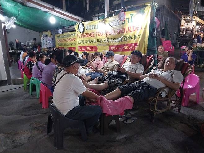 치앙마이 토요마켓에서 관광객들이 발 마사지를 받고 있다.