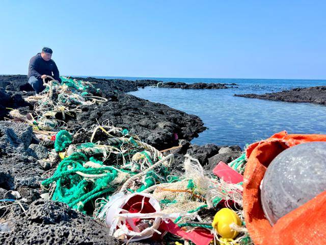 15일 제주시 김녕해수욕장 인근 덩개해안에서 김정도 제주환경운동연합 정책국장이 폐그물 등 떠밀려 온 해안쓰레기를 살펴보고 있다. 제주=변태섭 기자