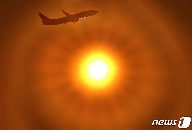 김포공항에서 이륙한 여객기가 붉게 타오르는 태양 앞으로 힘차게 날아 오르고 있다(뉴스1DB)ⓒ News1