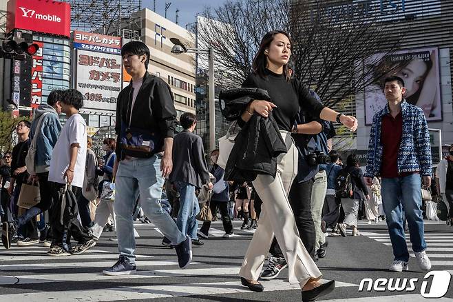 30일(현지시간) 일본 도쿄 신주쿠에서 시민들이 횡단보도를 건너고 있다. 일부는 겉옷을 벗거나 반팔을 입고 있다. 2024.03.30/ ⓒ AFP=뉴스1 ⓒ News1 권진영 기자