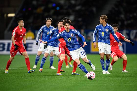 Japan's Ao Tanaka, center, controls the ball during a 2026 World Cup qualifier against North Korea at the National Stadium in Tokyo on March 21. [AFP/YONHAP]