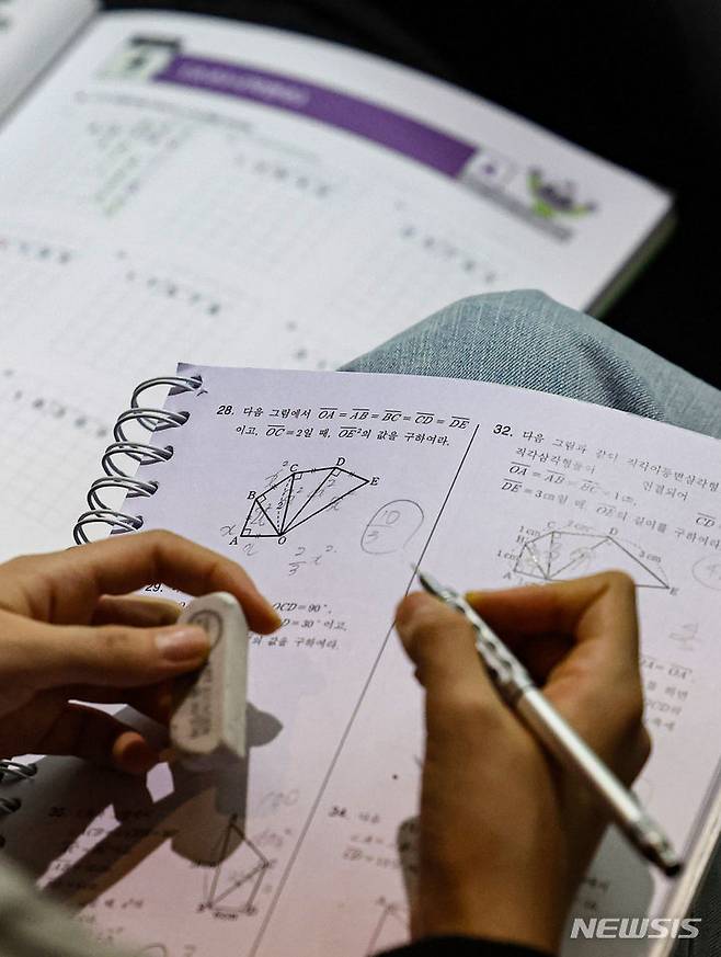 [서울=뉴시스] 권창회 기자 = 31일 오후 서울 종로구 성균관대학교 새천년홀에서 열린 종로아카데미 주최 ‘의대 모집정원 확대에 따른 향후 대학입시영향력 분석 설명회’에서 한 학생이 수학문제를 풀고 있다. 2024.03.31. kch0523@newsis.com