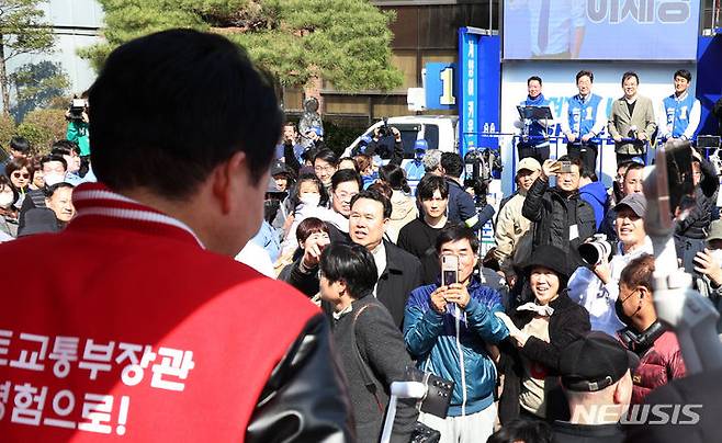 [인천=뉴시스] 이영환 기자 = 제22대 총선 인천 계양을 후보인 이재명 더불어민주당 대표가 31일 오후 인천 계양구 서운동성당 앞에서 유세를 하는 가운데 원희룡 국민의힘 계양을 후보가 유세를 하며 지나가고 있다. 2024.03.31. 20hwan@newsis.com