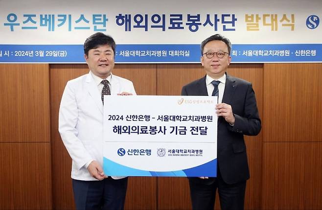 신한은행 정상혁 은행장(오른쪽)이 지난달 29일 서울대학교치과병원 이용무 병원장에게 해외의료봉사 기금을 전달하고 있다. 신한은행 제공