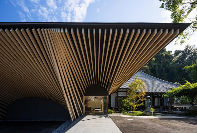 구마 겐코는 100년 된 도쿄 간조인 사원 옆에 깊은 처마를 가진 현대식 건물을 세웠다.