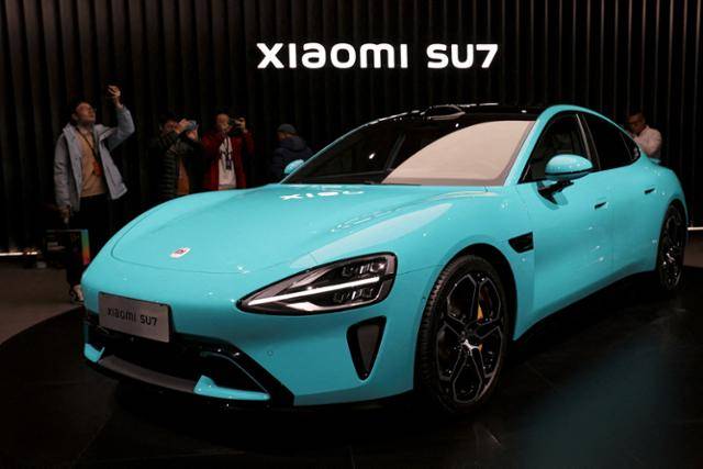 중국 전자업체 샤오미가 처음으로 선보인 전기차 모델 'SU7(Speed Ultra 7·중국명 수치)'. 사진은 지난달 28일 중국 베이징에서 열린 출시 행사 당시 관람객들이 SU7을 구경하고 있는 모습. 베이징=로이터 연합뉴스