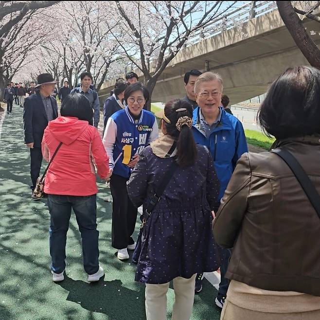 문재인 전 대통령이 1일 배재정 더불어민주당 후보를 격려하기 위해 부산 사상구를 깜짝 방문했다. 문 전 대통령은 배 후보와 부산 사상구 괘법동에 있는 낙동강 벚꽃길에서 시민들과 인사를 나누고 있다.  연합뉴스