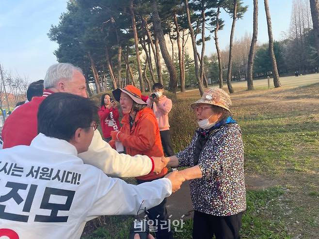 인요한 국민의미래 선거대책위원장과 김진모 충북 청주서원 후보가 청주 충북대학교 캠퍼스 내에서 주민과 악수를 하고 있다. ⓒ데일리안 오수진 기자
