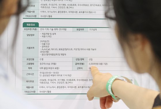 지난해 한 일자리 박람회에서 취업 준비생들이 기업의 채용 공고를 살펴보고 있다. 연합뉴스