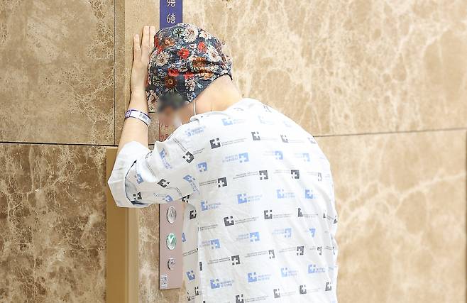 A patient leans on a hospital wall (Yonhap)