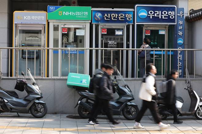 서울 시내에 설치된 시중은행 ATM 기기 앞을 시민들이 지나가고 있다./사진=뉴스1