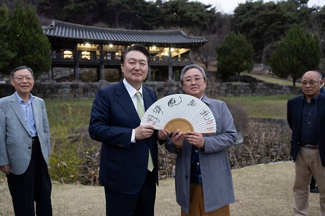 윤석열 대통령이 2일 충남 논산시 노성면 소재 파평 윤씨 가문 유생들의 후학 양성 시설인 종학당을 방문, 인간문화재 이기동 선생이 만든 부채를 윤두식 종회장으로부터 선물 받고 있다. [연합]