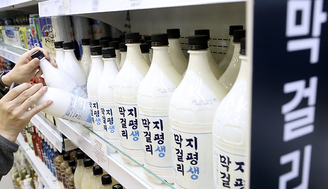 서울 한 마트에 직원이 지평 생 쌀막걸리를 정리하고 있다. 사진 = 뉴시스