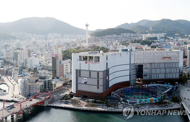 부산시 중구에 있는 롯데백화점 광복점. 바로 앞 공사현장이 부산롯데타워가 들어설 자리. 롯데그룹은 백화점과 함께 롯데타워를 지을 계획이었지만 20년 넘게 사업이 표류하고 있다. [연합뉴스]
