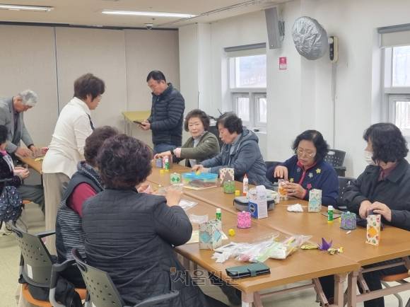 노인과 주민들이 노인복지관에서 공예품을 만들고 있다.