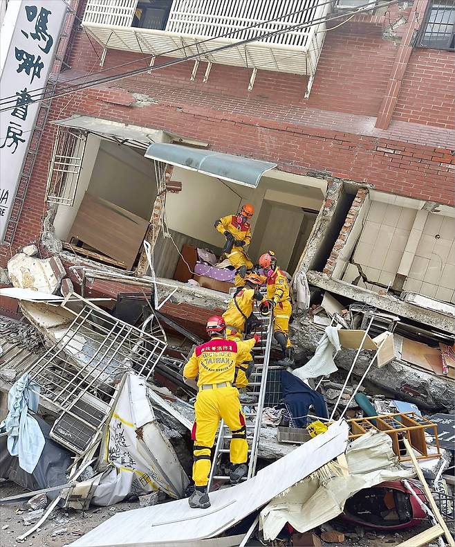 3일 규모 7.4 강진이 발생한 대만 동북부 도시 화롄에서 무너진 건물 사이로 구조대원들이 수색을 위해 진입하고 있다. 대만 소방당국은 137명이 건물 잔해에 갇혀 있다고 밝혔다.  /AP연합뉴스