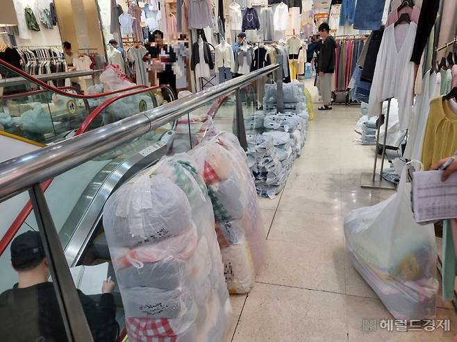 지난 3일 오전 1시께 찾은 동대문패션거리의 한 도매의류상가 모습. 자정부터 새벽 5시까지가 가장 바쁜 시간대다. 각 상가 내외부에서 옷가게 사장님들과 대신 물건을 받으러 온 ‘사입삼촌’들이 바삐 움직이고 있었다. 이민경 기자.