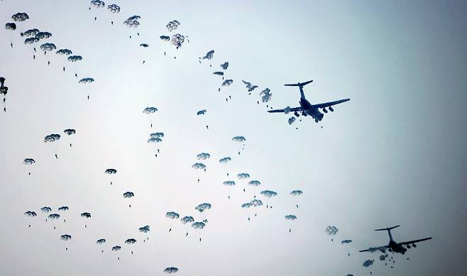 지난달 16일 북한이 공개한 항공육전병부대 강하 훈련 모습. 많은 인원이 한 번에 수송기에서 뛰어내리고 있다. 연합뉴스