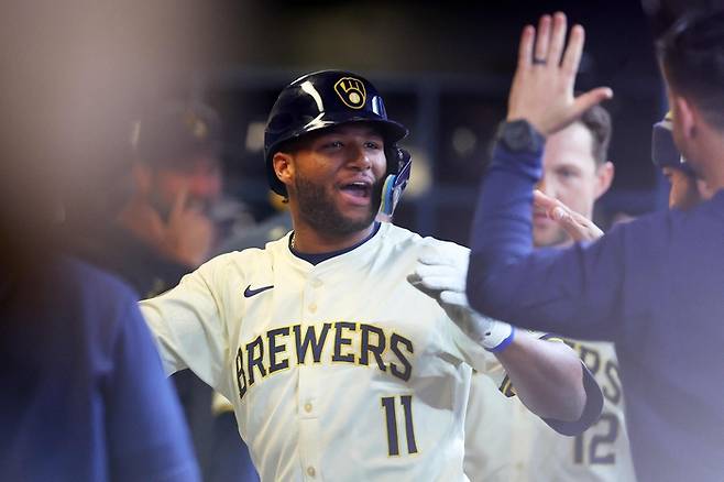 밀워키의 잭슨 츄리오가 4일 미국 밀워키의 아메리칸 패밀리 필드에서 열린 미네소타 트윈스와 홈경기에서 5회말 자신의 메이저리그 데뷔 첫 홈런을 친 뒤 더그아웃에서 동료들과 하이파이브하고 있다.     밀워키 | AFP연합뉴스