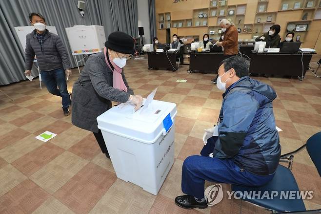 '이른 아침 투표 먼저' (제주=연합뉴스) 제21대 국회의원 선거 사전투표 첫날인 2020년 4월 10일 오전 제주시청에 마련된 이도2동투표소에서 유권자들이 투표함에 투표용지를 넣고 있다. [연합뉴스 자료사진]
