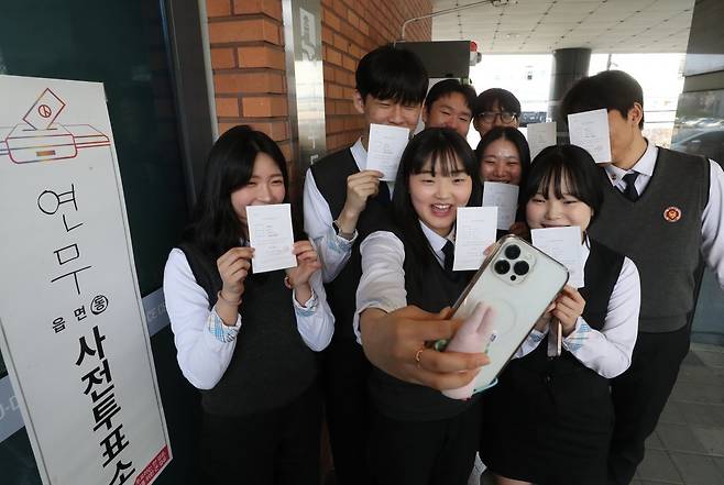 제22대 국회의원 선거 사전투표 첫날인 5일 오후 경기 수원시 장안구 연무동 행정복지센터에 마련된 사전투표소에서 사전투표를 마친 삼일공업고등학교 3학년 학생들이 투표확인증을 들고 인증샷을 남기고 있다. 2024.4.5. 뉴스1