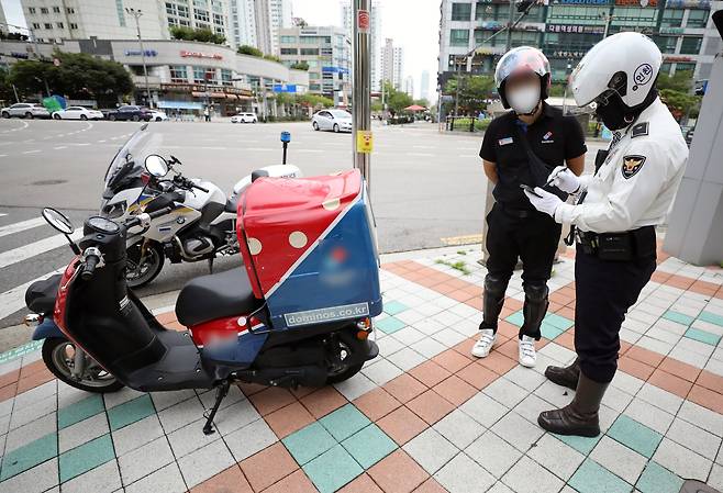 경찰이 인도로 불법 주행한 배달 오토바이 운전자를 단속하고 있다. 뉴스1
