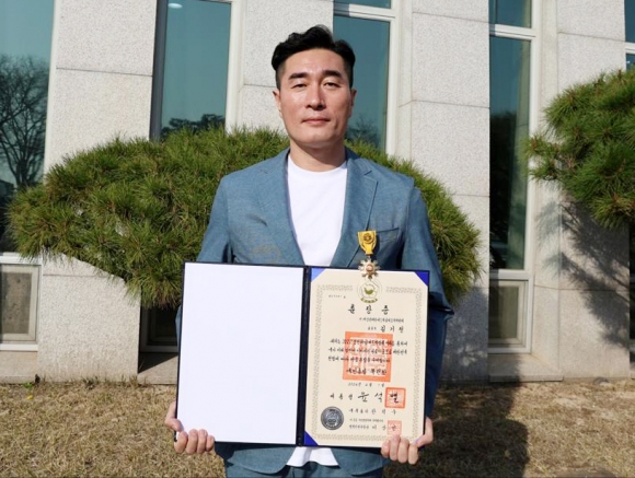 김기정 전 보령해양머드박람회 총감독이 2024년 정부 포상식에서 국민훈장 목련장을 받은 뒤 기념 촬영을 하고 있다.