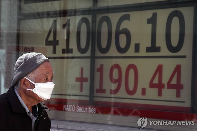 장중 4만1000 처음 돌파한 日 닛케이 (도쿄 AP=연합뉴스) 3월 22일 한 행인이 일본 도쿄 시내에 설치된 증시 시황판을 쳐다보고 있다. 이날 일본 증시 대표 주가지수인 닛케이225 평균주가(닛케이지수)는 사상 처음으로 장중 4만1000선을 돌파하며 사상 최고치를 기록했다. 2024.03.22 passion@yna.co.kr