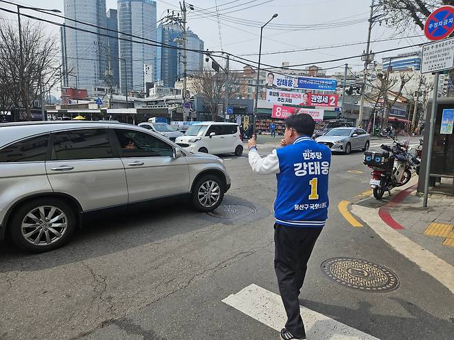 6일 오후 서울 용산 선거구의 더불어민주당 강태웅 후보가 용산구 후암시장 앞 사거리에서 그를 응원하는 한 차량 운전자에게 '쌍 따봉(양손 엄지 포즈)'을 하고 있다. /권순완 기자