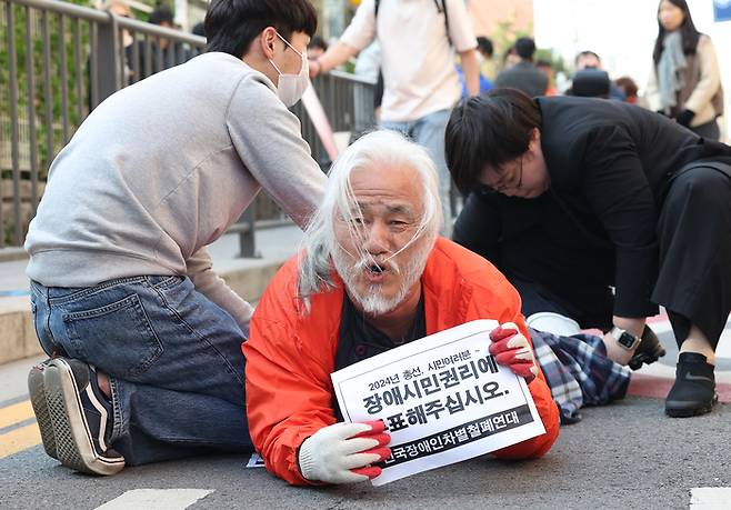 박경석 전국장애인차별철폐연대(전장연) 상임공동대표가 지난 5일 오후 서울 종로구 이화동주민센터 투표소 인근에서 장애인 인권 증진을 촉구하며 기어서 투표장으로 이동하고 있다. 연합뉴스