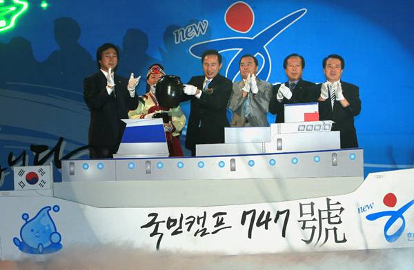 ▲ 2007년 7월13일 오후 서울 장충체육관에서 열린 '이명박후보 서울 선대위 발대식 및 당원 교육'에서 이명박 전 서울시장이 '국민캠프 747호' 선박 모형에 탑승한 채 전국에서 떠온 물을 담은 항아리를 들고 출항하는 퍼포먼스를 하고 있다. ⓒ 연합뉴스