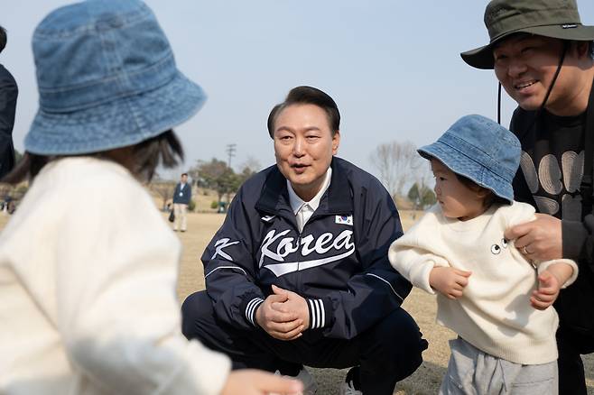 윤석열 대통령이 6일 서울 용산어린이정원 잔디마당을 찾아 한 가족과 대화하고 있다. [연합]