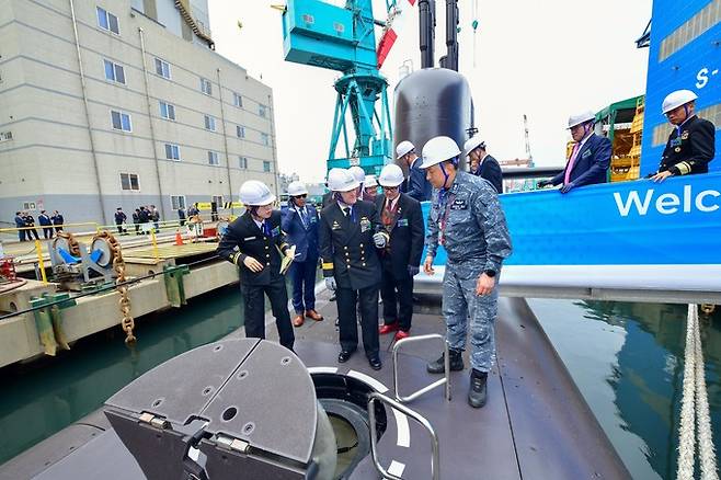 지난 4일 HD현대중공업 울산 조선소를 방문한 마이클 제이콥슨 호주 잠수함사령부 국장(가운데)이 잠수함 신채호함 선상에서 해군 관계자로부터 설명을 듣고 있다. HD현대중공업 제공
