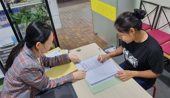 23일 오후 싱가포르 부킷티마에 있는 한 가사도우미 에이전시에서 미얀마 출신의 아웅쑤저(32)씨가 서류 작업을 하고 있다. 남편과 6년 전 싱가포르로 넘어온 그는 "쿠데타 등으로 고향 상황이 좋지 않은데, 싱가포르에 머물며 돈을 모을 수 있어 다행"이라고 말했다. /표태준 기자