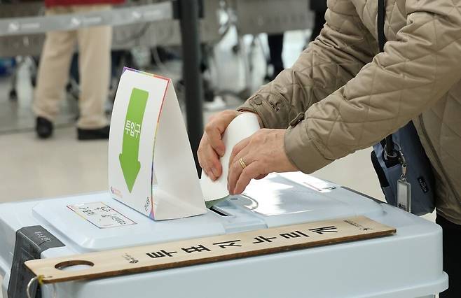 한 유권자가 투표용지를 투표함에 넣고 있다. 연합뉴스