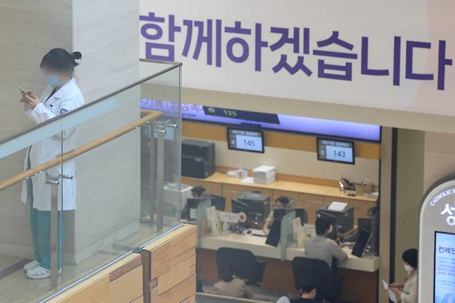 정부의 의대 정원 증원에 따른 의정갈등이 장기화하는 가운데 8일 서울 한 대학병원에서 간호사가 스마트폰을 하며 동료를 기다리고 있다. | 연합뉴스