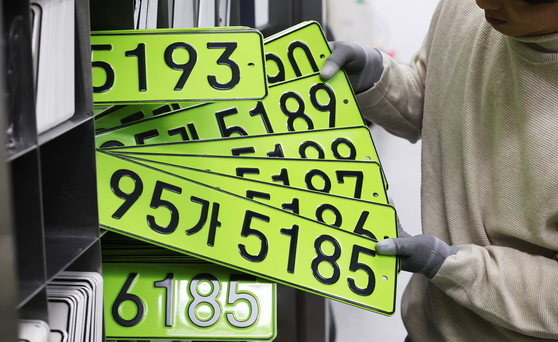 An official organizes green licenses plates, which will be attached on corporate cars acquired for more than 80 million won ($59,086) in January at the license plate manufacturing plant in Suwon, Gyeonggi. [YONHAP]