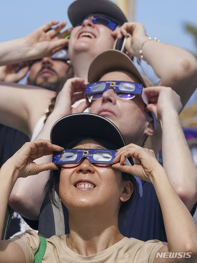 [마사틀란=AP/뉴시스] 8일(현지시각) 멕시코 마사틀란에서 한 가족이 관측경을 이용해 달이 태양을 완전히 가리는 개기일식을 관측하고 있다. 2024.04.09.