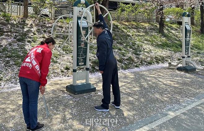 '충남 정치 1번지' 천안갑 지역구에 출마하는 신범철 국민의힘 후보 배우자 정혜진(51) 씨가 9일 원성천 일대 쓰레기를 수거하던 중 시민에게 인사하고 있다. ⓒ데일리안 강현태 기자