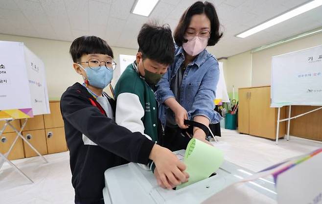 제22대 국회의원 선거일인 10일 오전 인천 미추홀구 용현여자중학교에 마련된 용현5동 제6투표소에서 한 유권자가 아이들과 함께 투표하고 있다.