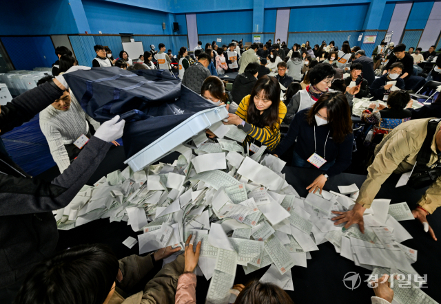 제22대 국회의원선거 투표일인 10일 오후 수원특례시 장안구 국민체육센터 배드민턴장에 설치된 개표장에서 관계자들이 개표하고 있다. 윤원규기자