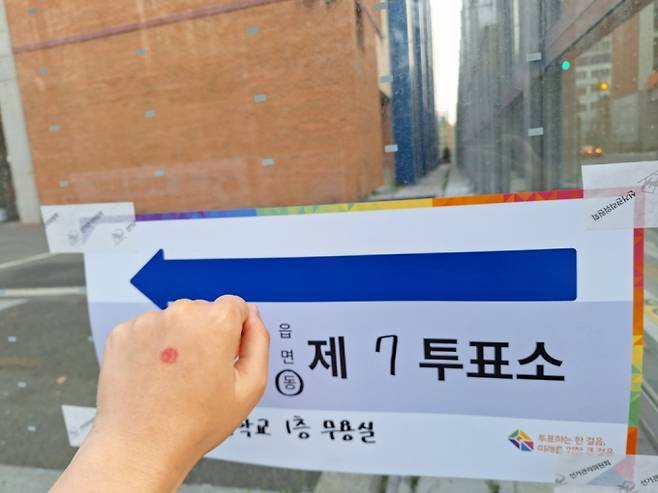 22일 오전 서울 영등포구의 한 투표소장에서 투표를 마친 시민이 인증샷을 찍는 모습./ 사진=김지은 기자