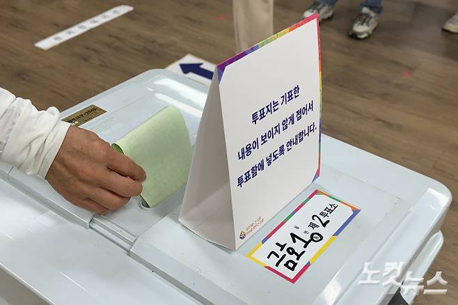 22대 총선 본투표소가 마련된 광주 서구 금호중학교에 10일 오전 6시 30분 유권자가 투표함에 투표용지를 넣고있다. 김수진 기자