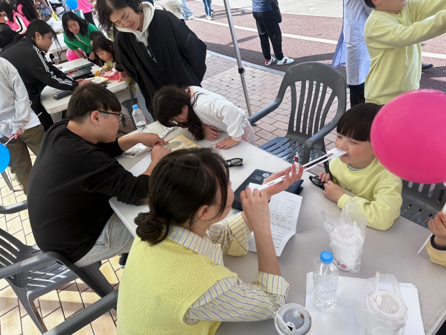 ▲마산대학교 안경광학과 학생들이 한국·일본 초등학생들과 학부모를 대상으로 검안 봉사활동을 펼치고 있다.ⓒ마산대
