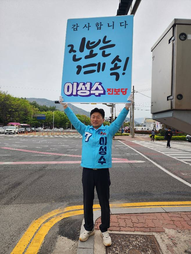 이성수 후보가 11일 아침 "진보는 계속"이란 푯말을 들고 시민들과 만나고 있다. 진보당 제공